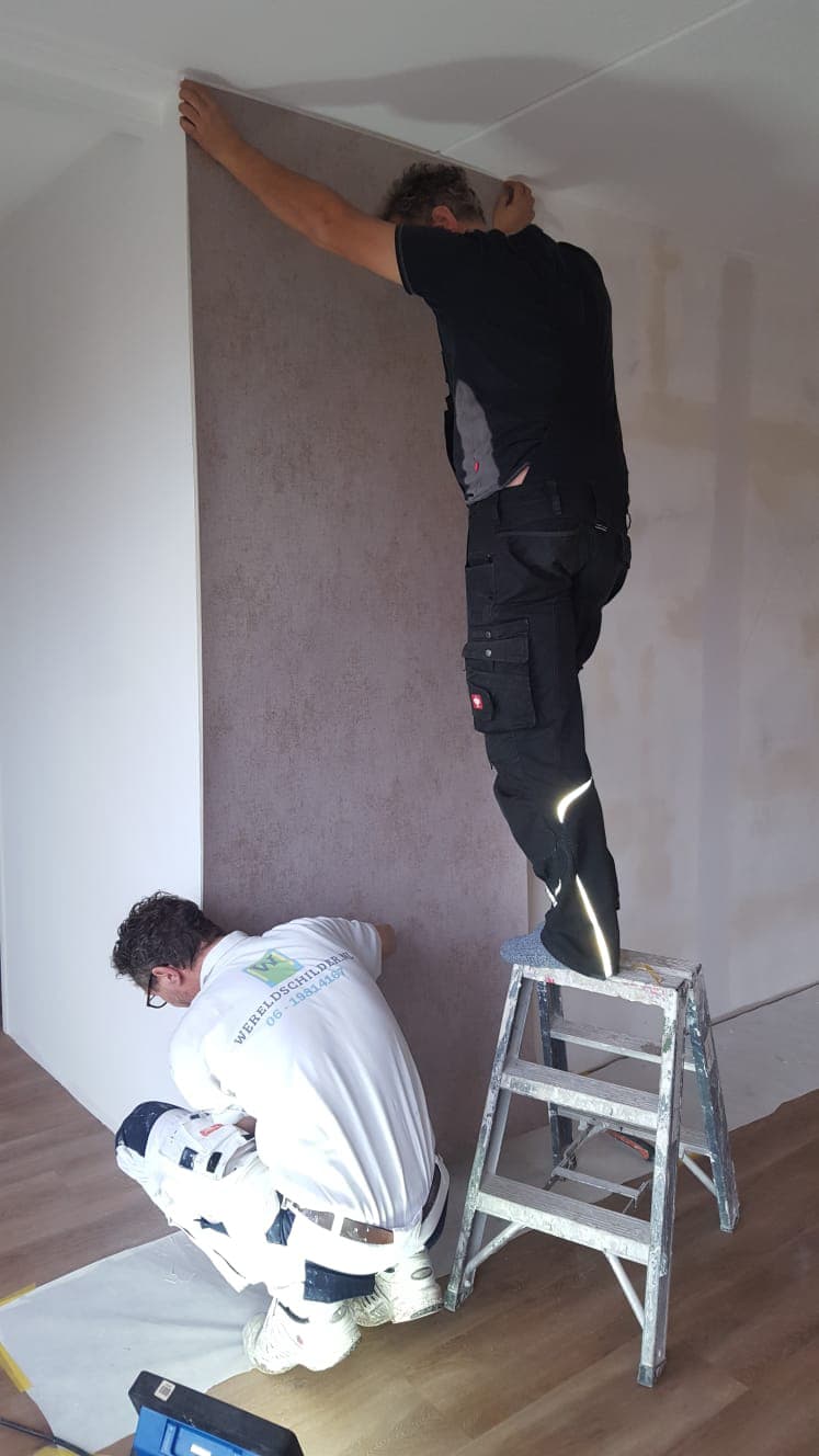 Behangers aan het werk aan een wand